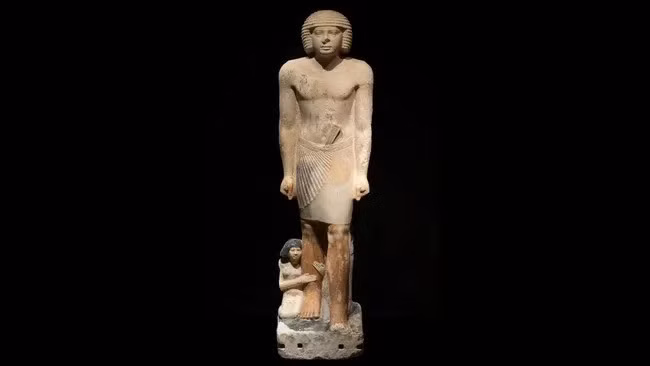 Các nhà khảo cổ đã tìm thấy một bức tượng độc đáo ở Saqqara, Ai Cập vào năm 2021. Hiện vật khắc họa hình ảnh một người đàn ông Ai Cập cổ đại đang đứng, người vợ đang ôm một bên chân phải của chồng và người con gái đứng phía sau, đang ôm một con ngỗng. Ảnh: Zahi Hawass.