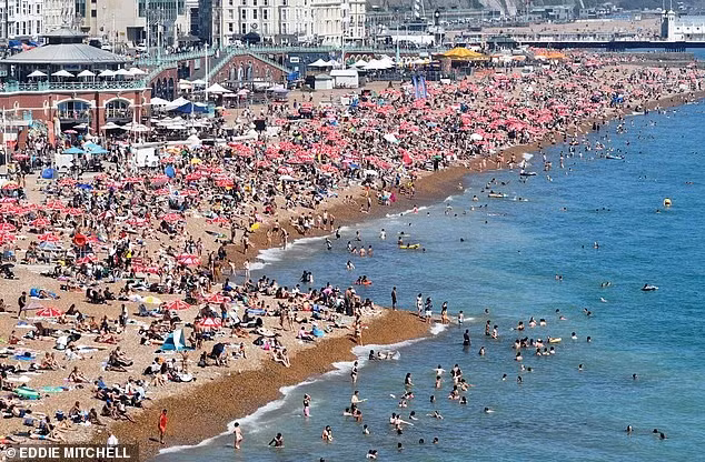 Bãi biển đông đúc ở Brighton, Anh, khi người dân đổ xô đến đây để giải nhiệt ngày nắng. Ảnh: Eddie Mitchell.
