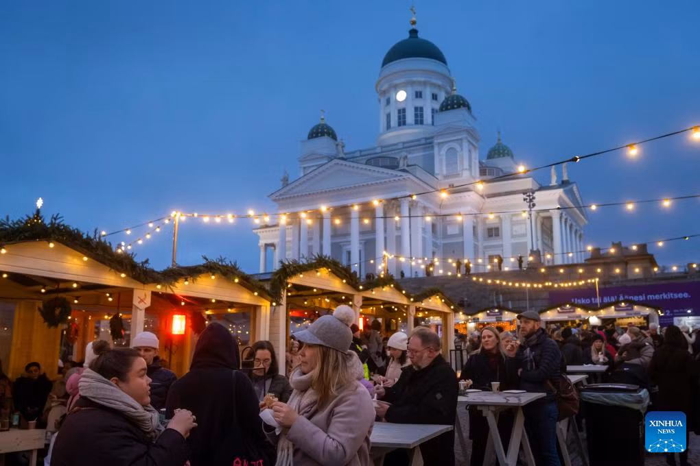 Mọi người thưởng thức đồ ăn và thức uống tại khu chợ Giáng sinh Helsinki ngày 5/12/2025.