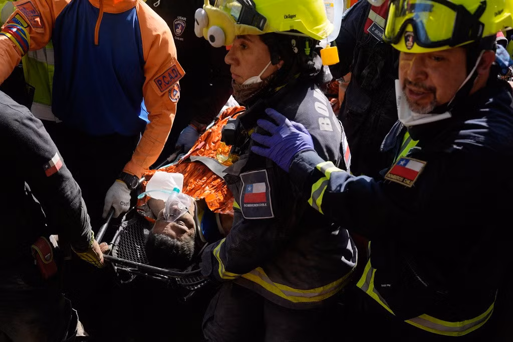 Các nhân viên cứu hộ Chile đưa Hernán Alberto Gil Flores ra ngoài hôm 2/7/2026 sau khi ông mắc kẹt 8 ngày sau khi bị mắc kẹt bởi hai trận động đất liên tiếp xảy ra ở Catia La Mar, Venezuela. Ảnh: AP/Fernando Vergara.