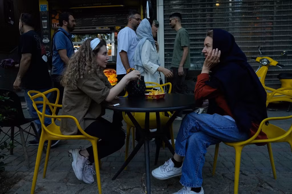 Hai cô gái ngồi ăn tại khu vực ăn uống ngoài trời của một nhà hàng ở thủ đô Tehran, Iran, ngày 1/5/2026. Ảnh: AP/Vahid Salemi.