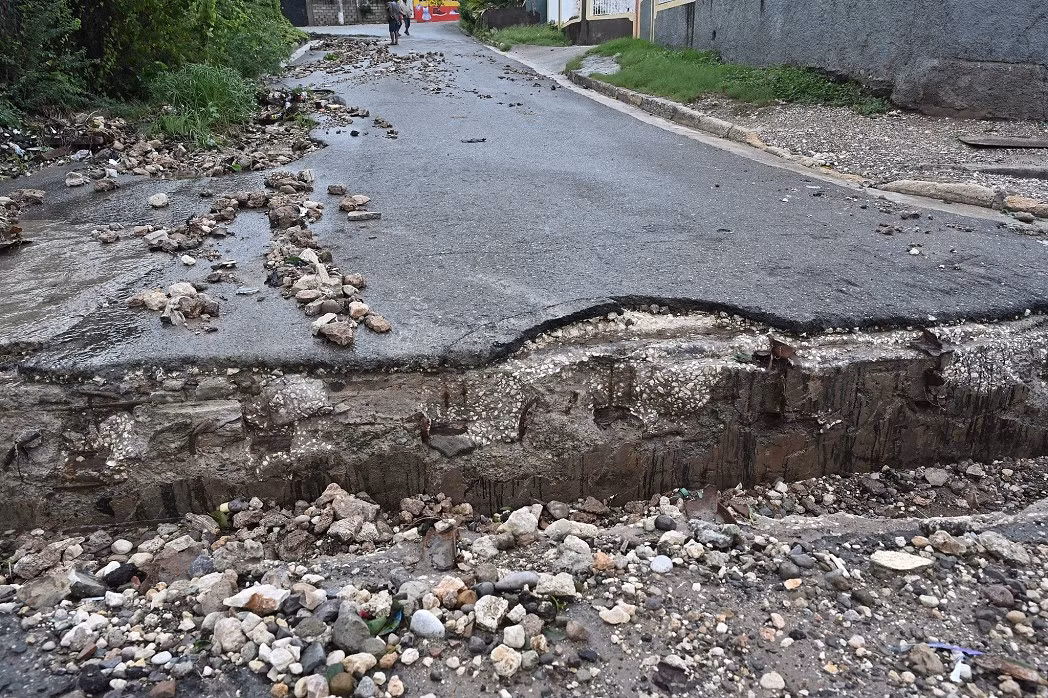 Việc bão Melissa di chuyển chậm có thể gây ra mưa lớn kéo dài ở một số khu vực, làm tăng nguy cơ lũ lụt chết người và lở đất. Ảnh: Con đường bị hư hại do bão Melissa ở Kingston ngày 28/10/2025. Ảnh: VCG.