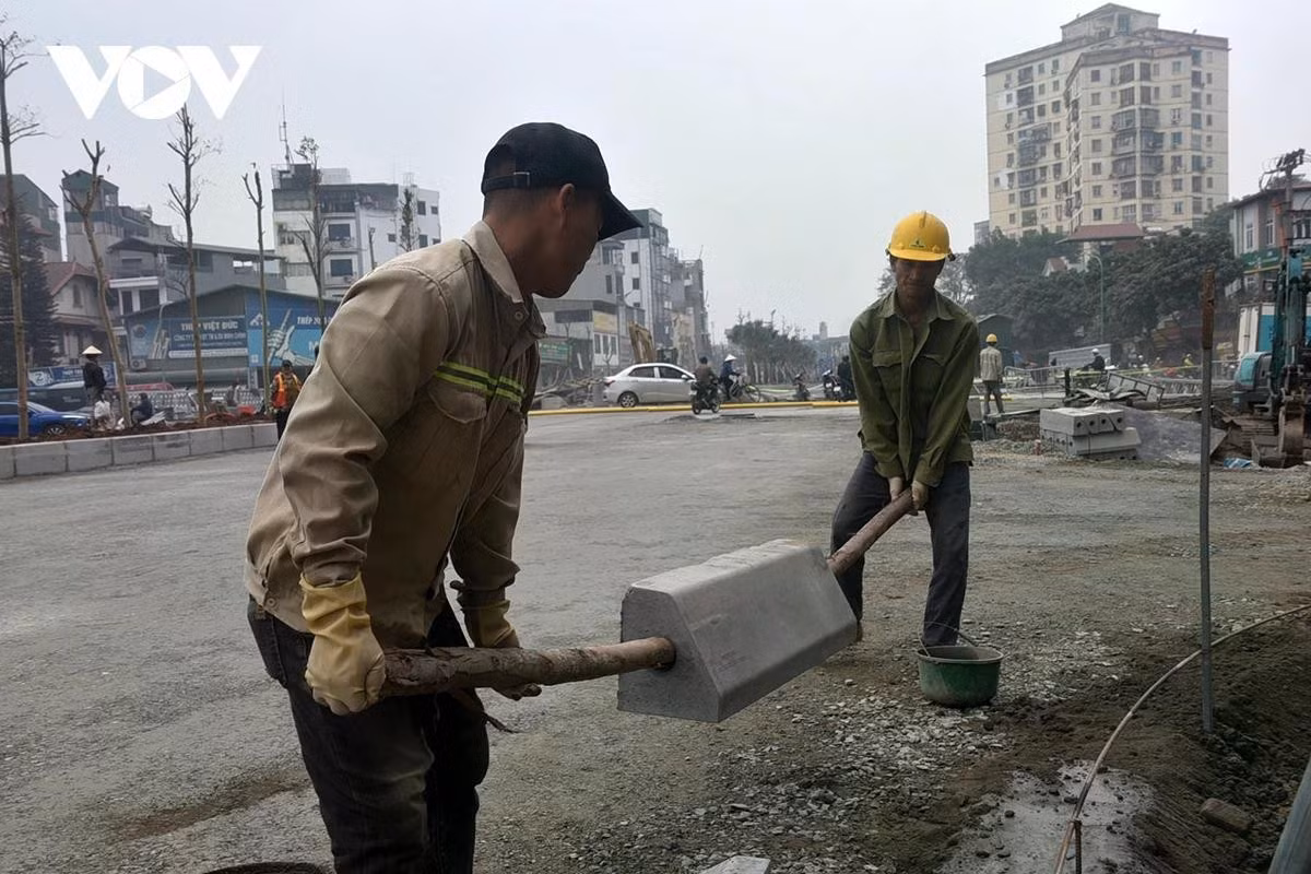 Công nhân đang thực hiện lát hè từ cầu L3 đến hầm chui Kim Đồng (đường Giải Phóng).