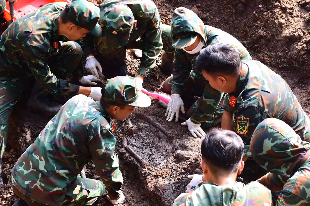 Lực lượng quy tập tỉ mỉ bóc tách từng lớp đất để tìm kiếm hài cốt liệt sĩ.