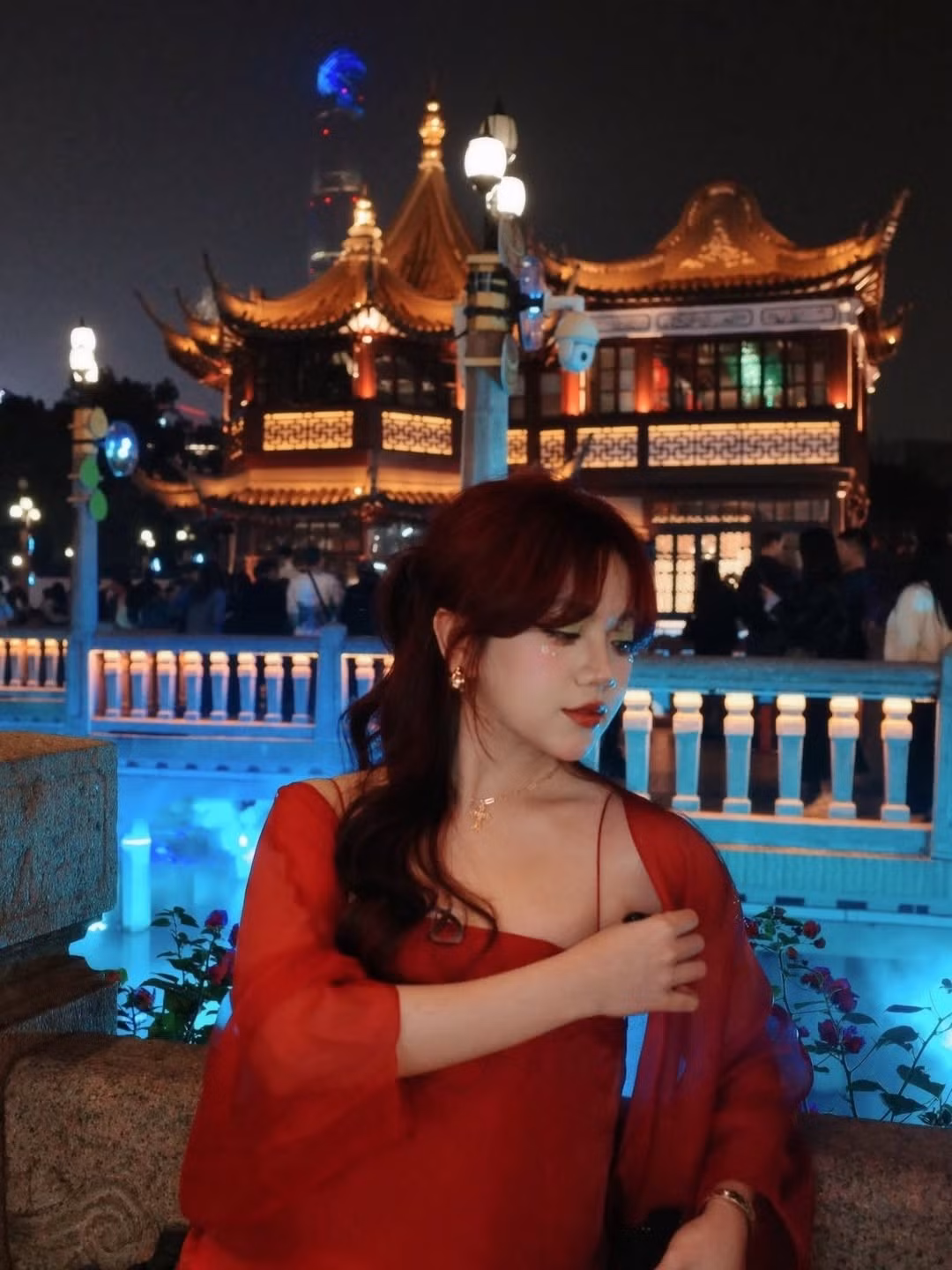 Mái tóc đỏ trầm được tạo kiểu uốn nhẹ, kết hợp layout makeup tông cam – hồng trong trẻo, nhấn vào đôi môi căng mọng và đôi mắt long lanh, khiến tổng thể diện mạo của Bảo Hân Helia trở nên vô cùng cuốn hút dưới ánh đèn đêm.