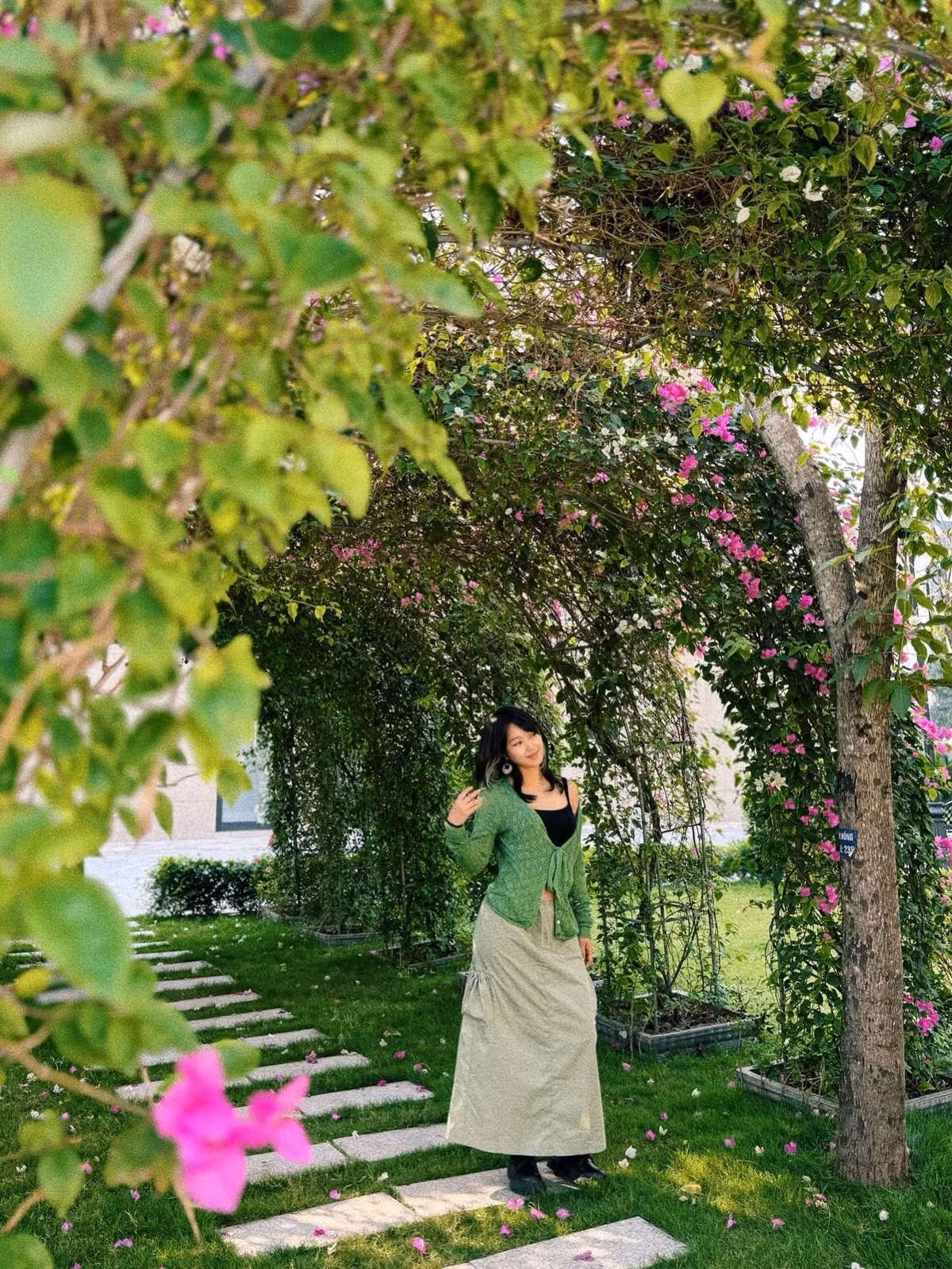 Trong những bức ảnh mới, Mi Vân xuất hiện giữa khung cảnh nên thơ của một vòm cây phủ đầy hoa giấy sắc hồng và trắng. Nắng nhẹ xuyên qua những tán lá tạo nên một bức tranh lãng mạn, càng tôn lên vẻ đẹp mềm mại của cô.