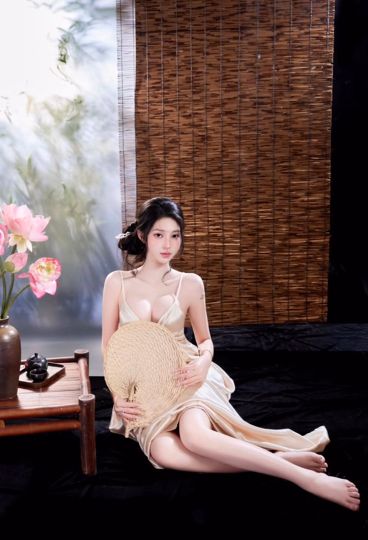 Tư thế ngồi tựa bên bàn trà, tay nhẹ nhàng chạm vào cánh sen, hay ánh mắt nhìn xa xăm đều toát lên thần thái vừa dịu dàng, thơ mộng, vừa ẩn chứa sức hút mãnh liệt, khiến ai nhìn vào cũng phải trầm trồ.