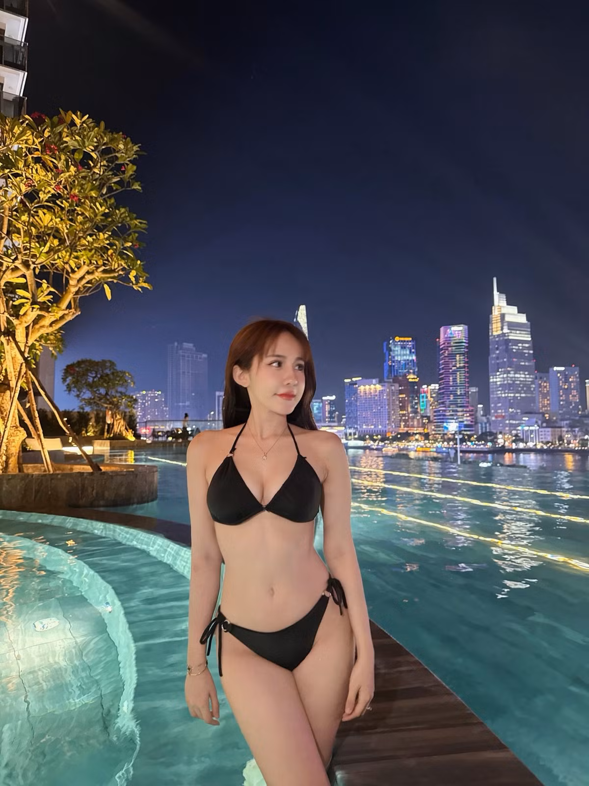 Trong bức ảnh, Tuyết Anh ngồi hờ hững bên thành bể bơi, mái tóc dài màu nâu hạt dẻ buông xõa lãng mạn, khuôn mặt trang điểm nhẹ nhàng nhưng nổi bật với nụ cười ngọt ngào và ánh mắt tươi tắn hướng về phía trước.
