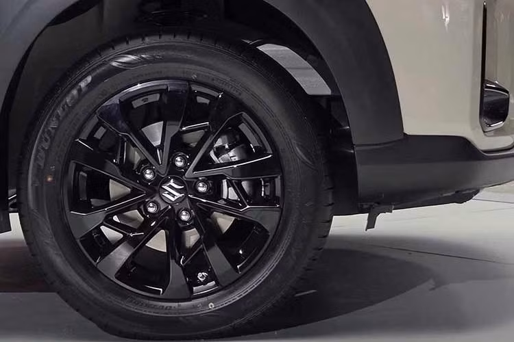 Ở hai bên thân xe, Suzuki XL7 2026 phiên bản nâng cấp mới có màu sơn hai tông và mâm hợp kim 16 inch màu đen toàn bộ, tay nắm cửa, thanh ray mái và gương chiếu hậu ngoài màu đen.
