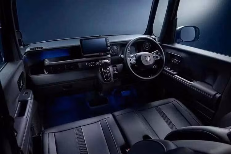 Bên trong khoang lái, Honda N-Box Custom 2027 được bổ sung các chi tiết trang trí crôm và sơn đen bóng piano, hệ thống đèn LED cùng đèn viền nội thất màu xanh dương Night Blue.
