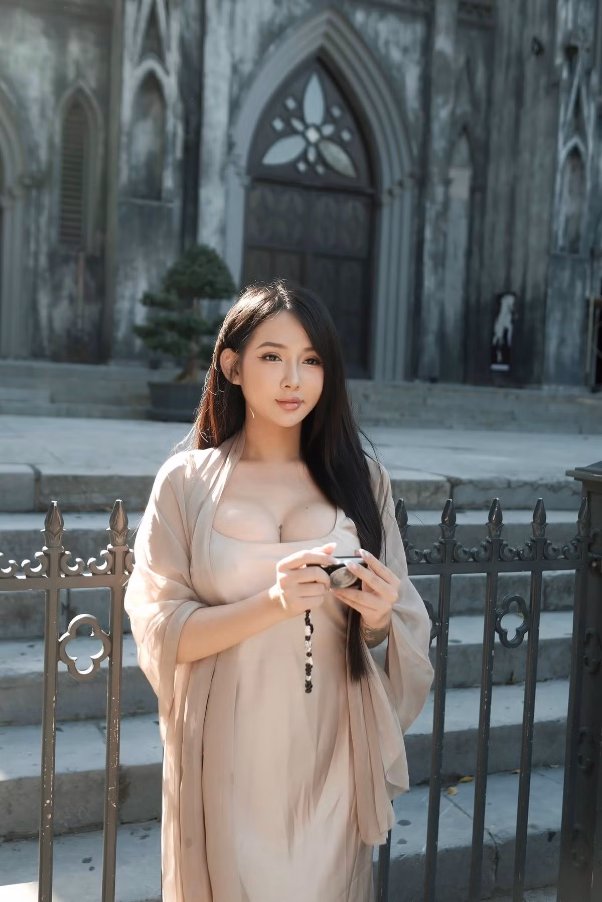 Trong bức ảnh mới đăng tải trên trang cá nhân, hot girl phòng gym Vy Vy Baby diện bộ váy lụa màu nude với lớp vải mềm, rũ ôm sát cơ thể giúp cô nàng trở nên nổi bật giữa không gian cổ kính phía trước nhà thờ.