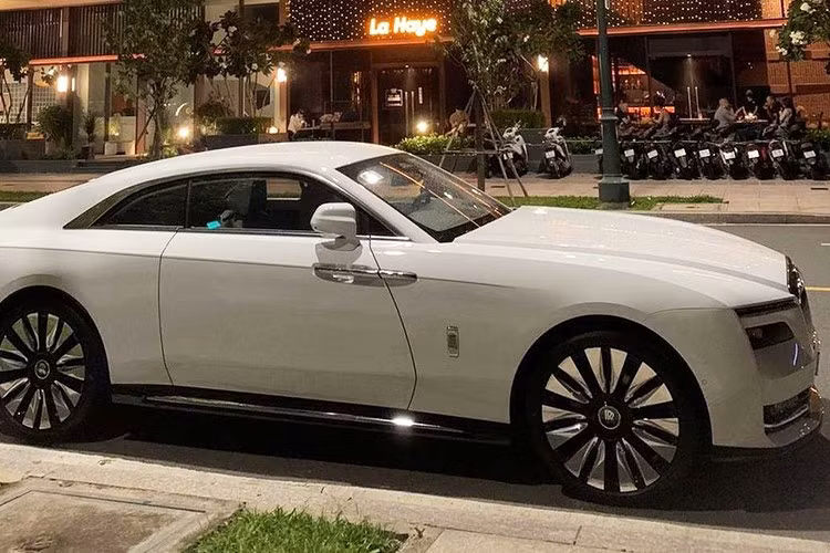 Chiếc xe siêu sang Rolls-Royce Spectre của đại gia Minh Nhựa có màu sơn trắng, điểm nhấn của xe nằm ở việc trên lưới tản nhiệt huyền thoại của một mẫu xe Rolls-Royce, chiếc coupe siêu sang chạy bằng điện Spectre này lại sở hữu logo Spirit of Ecstasy không phải bằng bạc hay mạ vàng quen thuộc mà là bằng chất liệu polycarbonate, hay nói dễ hiểu hơn là phát sáng vào ban đêm.
