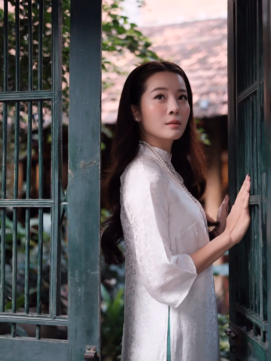 Trong bộ áo dài mang phom dáng truyền thống, Karen Nguyễn chọn thiết kế đơn giản, chất liệu nhẹ nhàng, họa tiết chìm tinh tế. Gam trắng chủ đạo giúp tôn lên làn da sáng mịn cùng vóc dáng thanh thoát của nữ diễn viên.