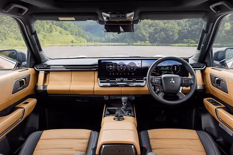 Bên trong, Mitsubishi Pajero 2027 mới sử dụng cấu hình 7 chỗ với ba hàng ghế. Hàng ghế giữa có thể trượt tiến/lùi trong phạm vi 150 mm, đồng thời được bổ sung bàn gấp, ngăn chứa đồ và cổng sạc USB-C. Ghế bọc da mềm, hoàn thiện bằng kỹ thuật may Kimekomi nhằm tăng cảm giác cao cấp.