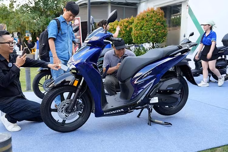 Điểm nhấn đáng chú ý nhất của bộ sưu tập SH ITALIA New Concept Design 2026 là phiên bản Honda SH150i Vetro Blue. Mẫu xe sở hữu tông màu xanh bán trong suốt với hiệu ứng ánh sáng biến đổi theo từng góc nhìn. Theo công bố, bộ dàn áo của xe được phát triển từ vật liệu polyme kỹ thuật cao kết hợp vi hạt thủy tinh siêu nhỏ nhằm tạo hiệu ứng phản xạ và khúc xạ ánh sáng tương tự pha lê.