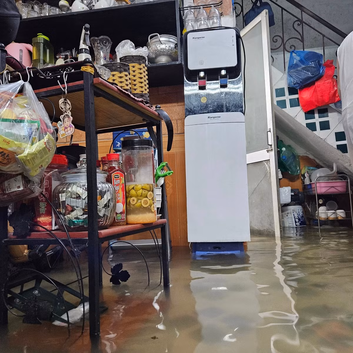 Để bảo vệ tài sản, nhiều hộ dân trong ngõ đã phải đi nhặt gạch để kê cao những chiếc tủ lạnh, cây nước, xe máy... Ảnh: Cảnh nước ngập vào 1 hộ gia đình tại ngõ 166 Kim Mã - phường Ngọc Hà - Hà Nội sáng ngày 26/8/2025.