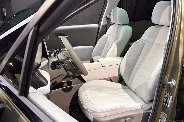 Khu vực phía trước ghế hành khách có thêm khay chứa đồ dạng mở, gợi liên tưởng đến cách bố trí trên Hyundai SantaFe. Đáng chú ý, cần số điện tử được chuyển lên phía sau vô-lăng, giải phóng không gian tại bệ trung tâm. Nhờ đó, khu vực này có thêm các hộc chứa đồ, vị trí đặt cốc và khay để thiết bị điện tử.