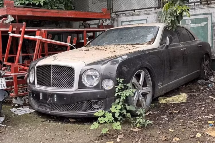 Nhìn vào ngoại thất chiếc xe Bentley Mulsanne bị "vứt xó" ở sân bóng Hà Nội này, này sẽ khiến không ít người tiếc vì xe bị hư hỏng 4 phuộc hơi, ngoại thất thì bám đầy bụi, nhiều khả năng xe đã đỗ ở đây nhiều tháng, có khi là tính bằng năm.