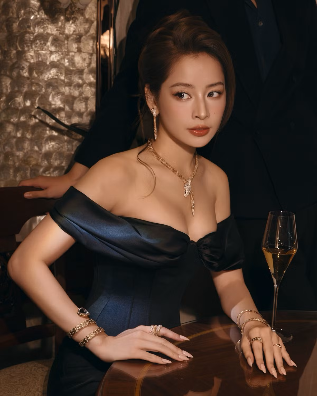 Điểm nhấn nằm ở bộ trang sức ánh vàng gồm vòng cổ, bông tai và vòng tay, tạo hiệu ứng lấp lánh vừa đủ, làm nổi bật làn da trắng mịn của người đẹp sinh năm 1993.