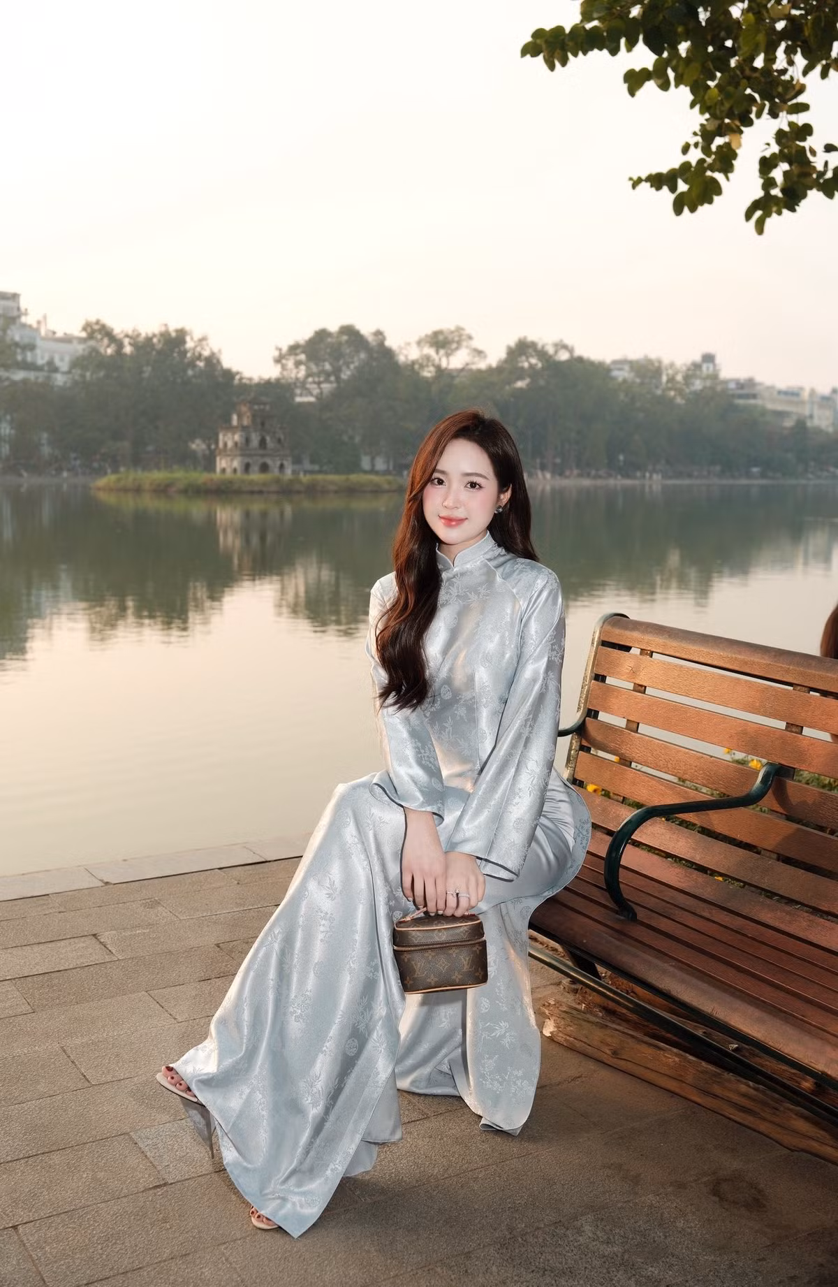 Trong loạt ảnh, Lê Phương Anh diện chiếc áo dài lụa màu bạc ánh kim, họa tiết nhẹ nhàng tinh tế. Chất liệu mềm mại ôm lấy cơ thể giúp tôn lên vóc dáng thon thả, đường cong nữ tính của hot girl sinh năm 1997.