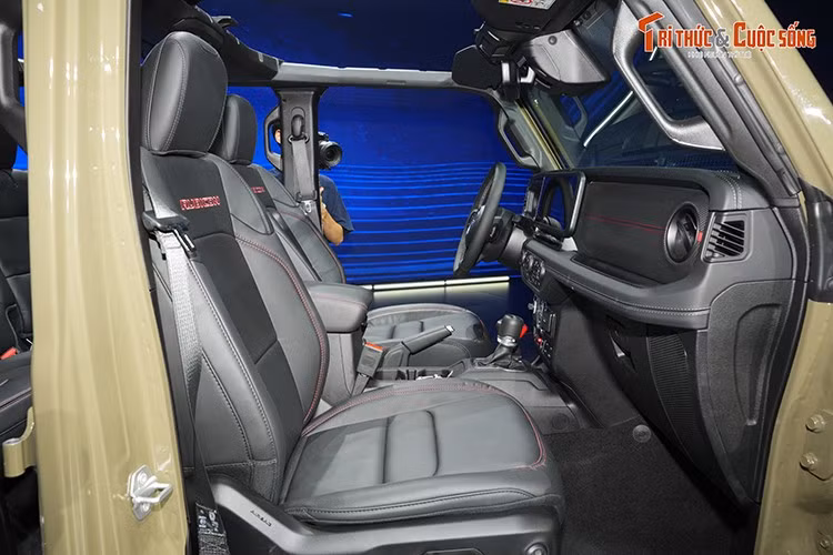 Khoang cabin của Jeep Wrangler 2026 là nơi có nhiều nâng cấp rõ rệt nhất. Trung tâm bảng táp-lô nổi bật với màn hình giải trí 12,3 inch mới, hỗ trợ Apple CarPlay và Android Auto không dây. Phía sau vô-lăng là cụm đồng hồ kết hợp giữa dạng cơ truyền thống và màn hình LCD hiển thị thông tin vận hành.