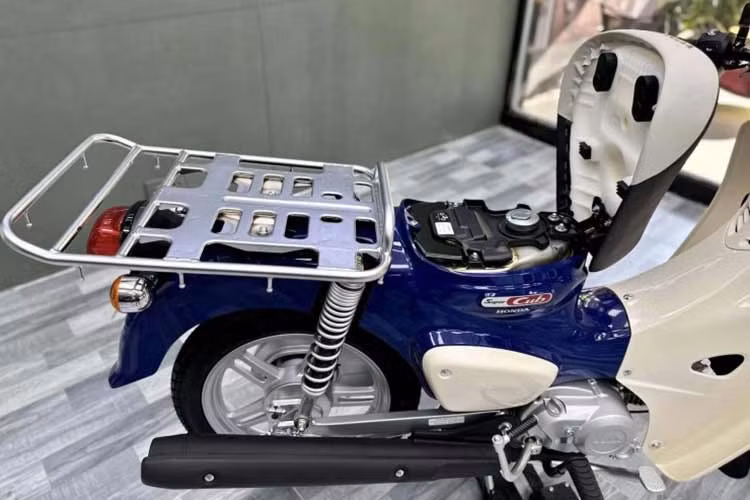 Phía sau là baga bản rộng bằng kim loại dùng để chuyên chở hàng hoá, khung xe lộ rõ và hệ thống treo gia cố, tạo cảm giác thực dụng hơn là thời trang. Tổng thể xe vì vậy trông “thô” và lạ mắt, thiên về công năng chuyên chở thay vì tính thẩm mỹ quen thuộc của dòng Cub truyền thống.