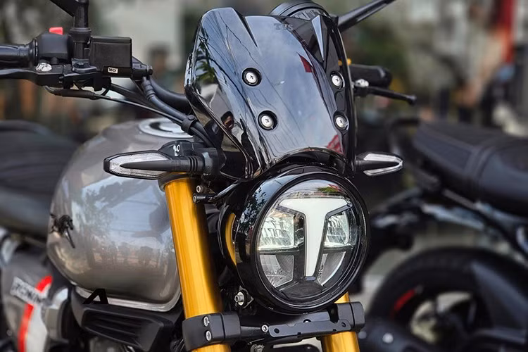 Mẫu xe môtô giá rẻ TVS Ronin 225 mang kiểu dáng Scrambler đặc trưng với những đường nét bo tròn hoài cổ kết hợp cùng các trang bị hiện đại. Điểm nhấn dễ nhận diện nhất của xe là cụm đèn pha LED tròn tích hợp dải định vị ban ngày chữ T đặt chính giữa.