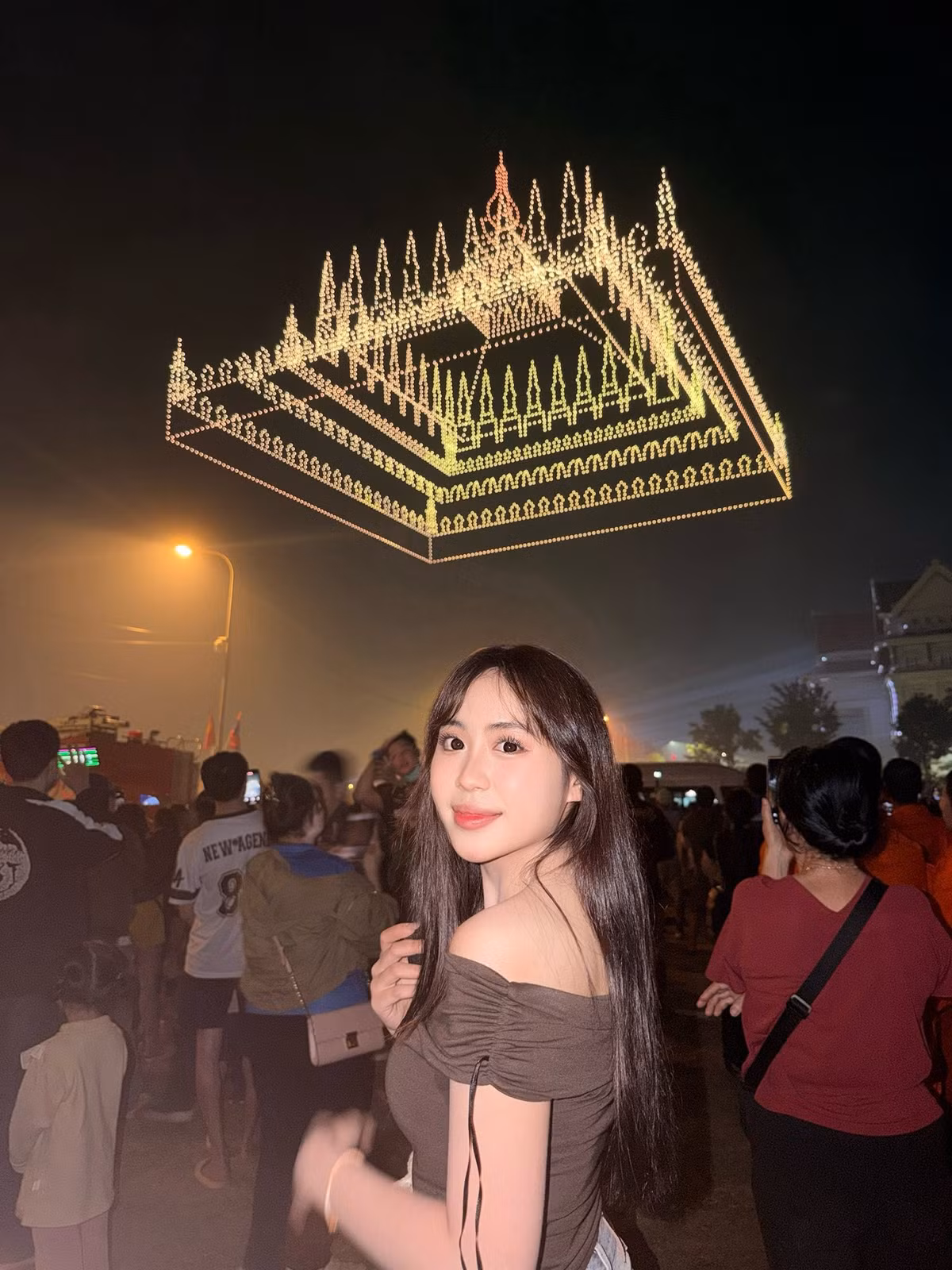Nét đẹp của cô càng trở nên rực rỡ dưới ánh sáng lung linh của pháo hoa và hàng nghìn chiếc drone tạo hình trên bầu trời. Từ lá cờ Lào, công trình kiến trúc đặc trưng đến hình tượng voi trắng – biểu tượng văn hoá Lào – tất cả đều tạo nên phông nền hoàn hảo để tôn lên thần thái cuốn hút của Maysaa.