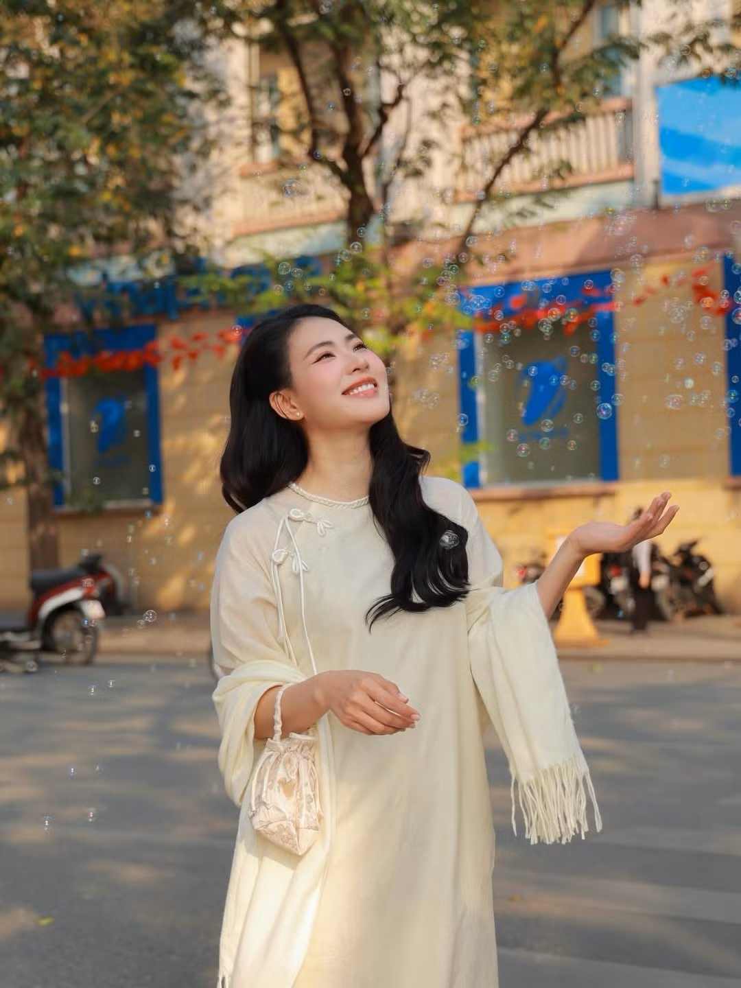 Giữa không gian Hà Nội cổ kính, Nguyễn Minh Trang lựa chọn áo dài dáng suông mềm mại, tôn lên vẻ nữ tính và thần thái an nhiên. Thiết kế tối giản, gam màu trang nhã giúp tổng thể thêm thanh thoát, hài hòa với bối cảnh Hồ Gươm nắng nhẹ.