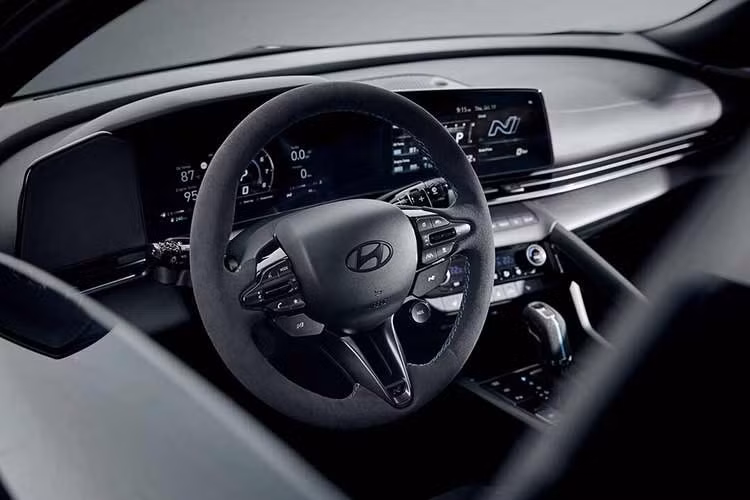 Khoang nội thất được phủ chất liệu Alcantara tại các vị trí như ghế ngồi, ốp cửa, vô-lăng và bệ tỳ tay trung tâm. Điểm nhấn cabin nằm ở các đường chỉ khâu màu xanh nhạt tương phản kết hợp cùng hệ thống nút bấm màu đen trên vô-lăng.