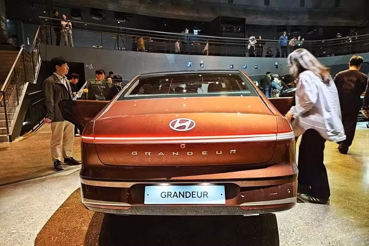 Ở bên sườn, Hyundai Grandeur 2026 sở hữu chi tiết ốp chắn bùn trước tích hợp đèn báo rẽ tạo hiệu ứng ánh sáng liền mạch từ trước ra sau. Đây cũng là mẫu sedan đầu tiên của Hyundai sử dụng ăng-ten ẩn thay cho dạng vây cá mập truyền thống, giúp thiết kế tổng thể trở nên gọn gàng hơn.