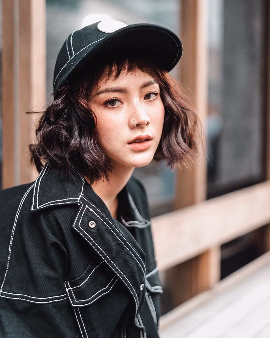 Mái tóc ngắn bồng bềnh, kết hợp màu nâu trầm nhẹ nhàng, khiến gương mặt cô thêm sáng, tôn lên làn da mịn màng và đôi mắt cuốn hút.