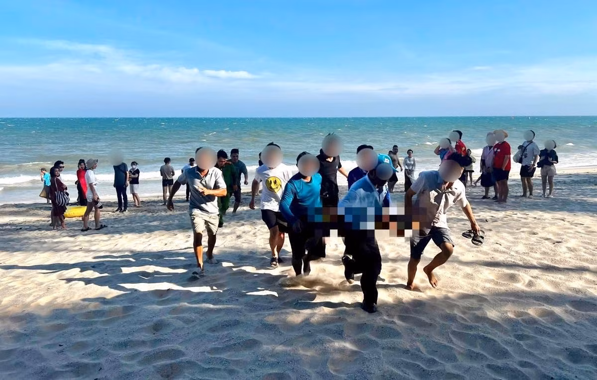 2 anh em du khách tắm biển bị đuối nước và được cứu đưa lên bờ nhưng người em đã tử vong. (Ảnh: Duy Tuấn)