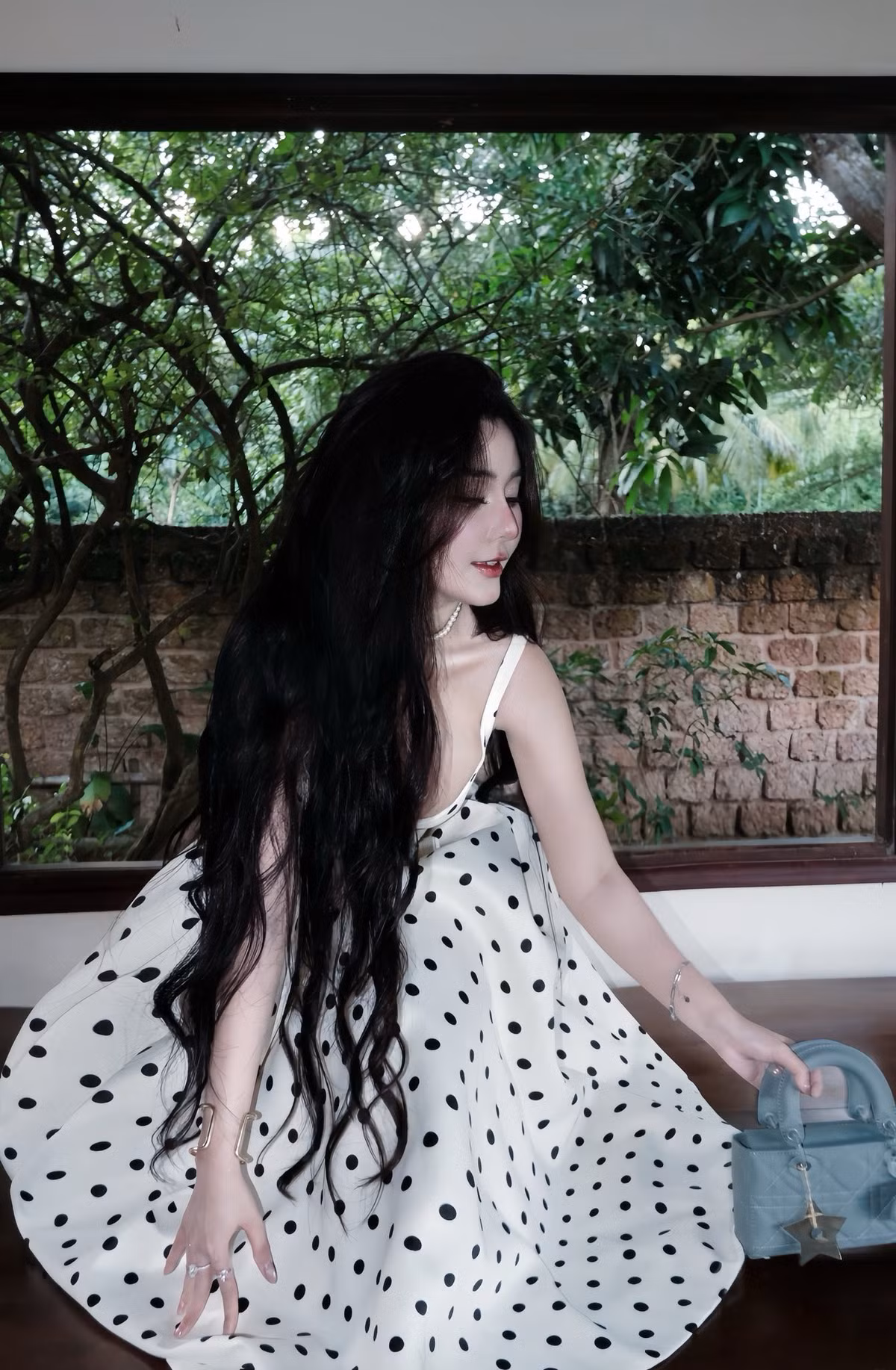 Không chỉ xinh đẹp, Ngọc Trân còn ghi điểm bởi gu thời trang tinh tế. Váy chấm bi cổ điển kết hợp phụ kiện tối giản như vòng cổ mảnh, nhẫn bạc và hoa tai nhỏ xinh giúp cô giữ được sự thanh lịch, không phô trương nhưng vẫn đầy cuốn hút.