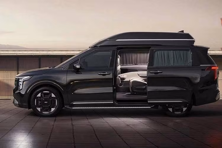 Điểm khác biệt lớn nhất của Kia Carnival High Roof 2026 nằm ở thiết kế phần nóc xe được nâng cao thêm 270 mm so với bản tiêu chuẩn. Nhờ đó, mẫu xe mang đến không gian trần xe rộng rãi hơn đáng kể, đặc biệt ở hàng ghế thứ hai và thứ ba.