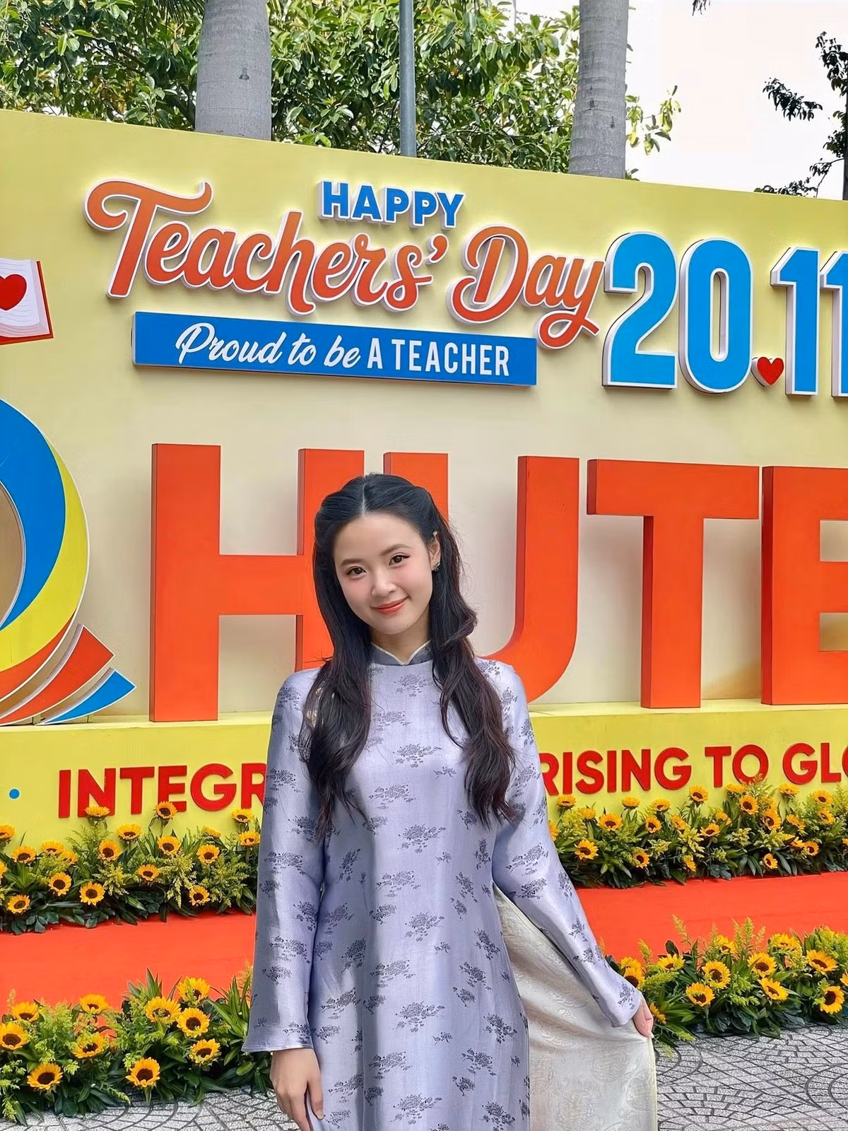 Mái tóc dài buông nhẹ được uốn xoăn sóng, tô điểm cho gương mặt thanh tú. Nụ cười nhẹ nhàng và ánh nhìn hiền hòa khiến tổng thể càng thêm cuốn hút.