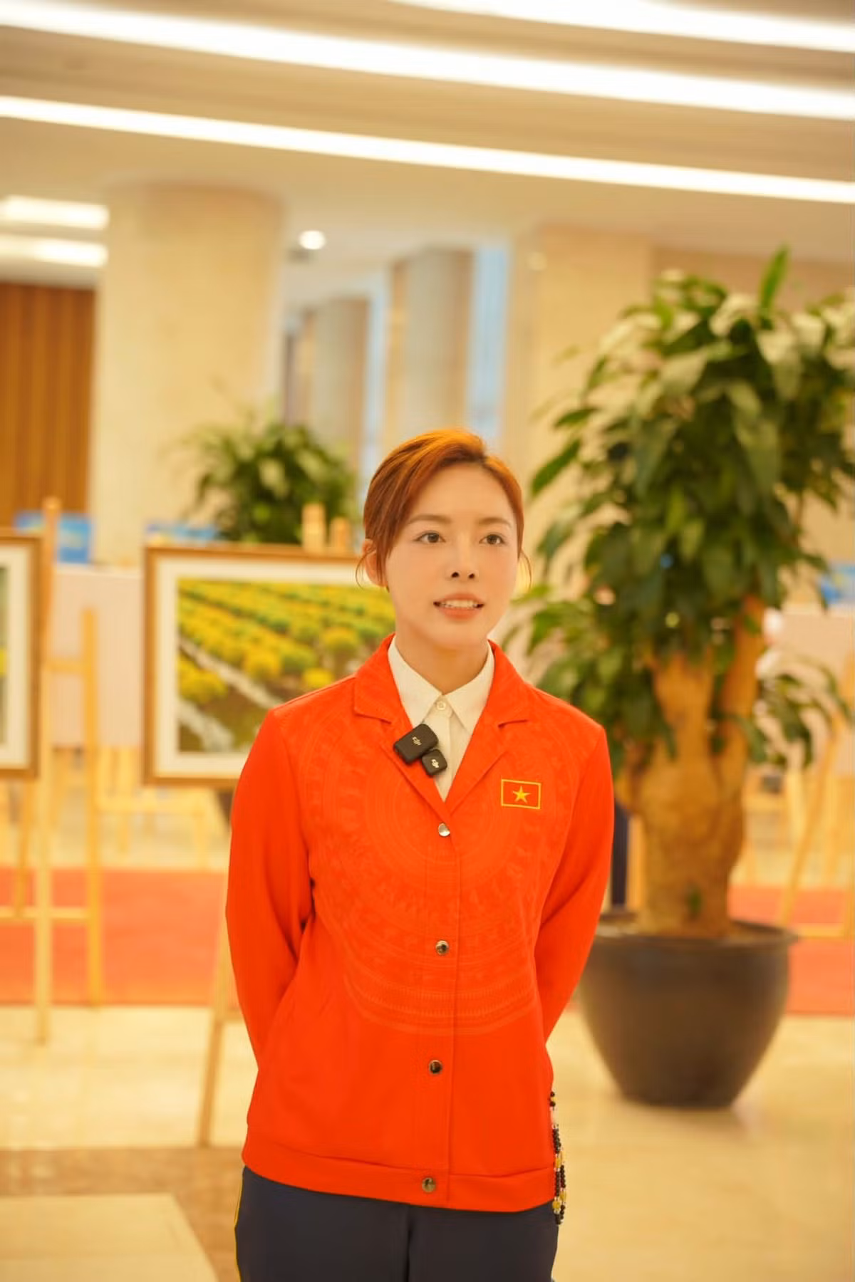 Trong bộ đồng phục đỏ truyền thống của Đoàn thể thao Việt Nam, Phí Thanh Thảo gây ấn tượng với gương mặt thanh tú, nụ cười nhẹ nhàng và thần thái vô cùng quyết đoán. Làn da sáng, đường nét hài hòa cùng ánh mắt tập trung, sắc sảo giúp cô nổi bật giữa khung cảnh trang trọng của buổi lễ.