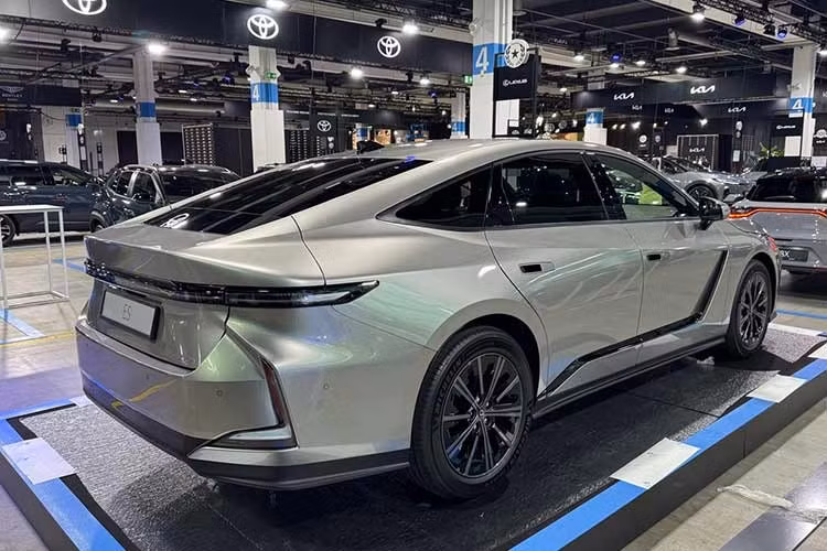 Về ngoại hình, ES 2026 có những thay đổi đáng kể về mặt thiết kế và trang bị. Điểm nhấn của khu vực ngoại thất nằm ở lưới tản nhiệt hình con suốt sơn cùng màu thân xe. Trên các phiên bản hybrid, xe sẽ được trang bị lưới tản nhiệt hẹp để tăng khả năng làm mát. Trong khi đó, phiên bản thuần điện lại sở hữu khu vực đầu xe tối giản hơn với lưới tản nhiệt đóng kín.