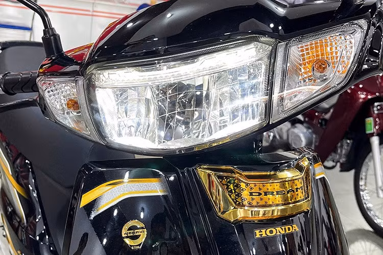 Ngoài bộ tem kèm dòng chữ "Dream" chạy dọc hai bên thân xe, phần góc yếm trước của Honda Dream NCX 2026 còn được trang trí viền tem mới. Phần đầu xe ũng được trang bị đèn LED toàn bộ, bao gồm đèn pha, đèn hậu và đèn xi-nhan phong cách cổ điển, tạo nên vẻ sang trọng nhưng vẫn tiện dụng cho việc sử dụng hàng ngày.