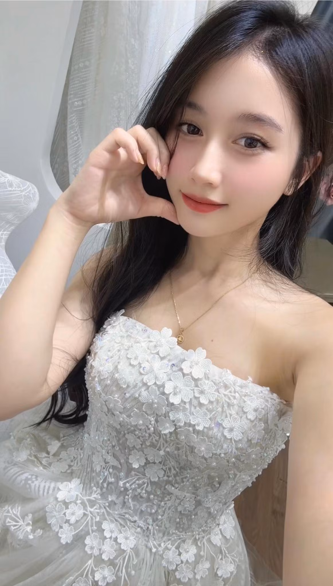 Hot girl bán phở lựa chọn phong cách trang điểm nhẹ nhàng, tôn lên làn da trắng hồng cùng đường nét gương mặt thanh tú. Mái tóc đen dài buông xõa, ánh mắt hút hồn và nụ cười dịu dàng, đắm say.