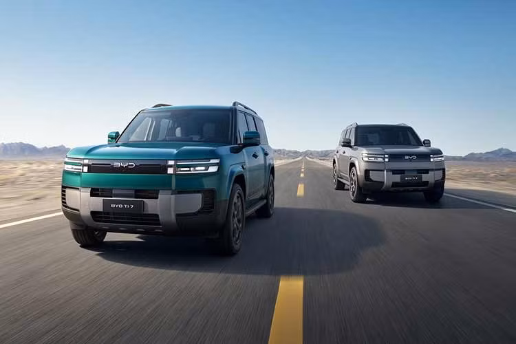 Về thiết kế, BYD Ti7 có ngoại hình khá bắt mắt. Phần đầu xe được tạo điểm nhấn bằng cụm đèn LED tách tầng dạng mảnh, các hốc gió nhỏ màu đen và cản trước sơn tối màu. Xe cũng mang dáng vẻ cứng cáp nhờ vòm bánh vuông vức, gương chiếu hậu và tay nắm cửa kích thước lớn, nóc kính toàn cảnh cùng bánh dự phòng đặt ở cửa cốp sau.
