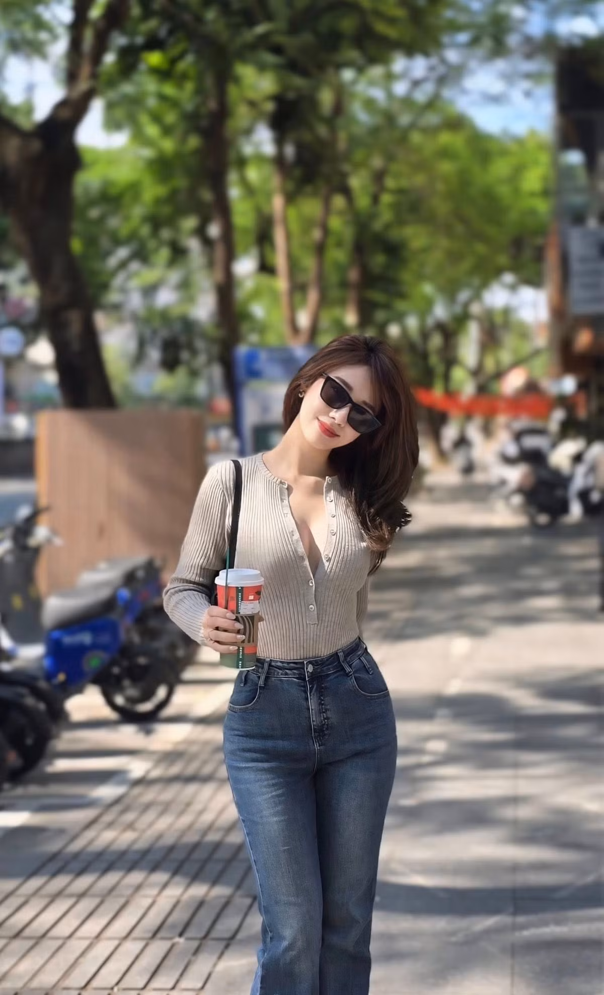 Phụ kiện đi kèm như túi xách nhỏ, kính râm và ly cà phê trên tay càng khiến hình ảnh của Hà Kim thêm phần thời thượng, hiện đại.
