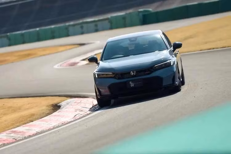 Honda Civic e:HEV RS 2026 mới được trang bị bộ mâm hợp kim 18 inch được lấy từ các phiên bản e:HEV cao cấp hơn và có lớp sơn đen mờ Berlina Black, trong khi ống xả kép vẫn hiện diện nhưng được bịt kín.
