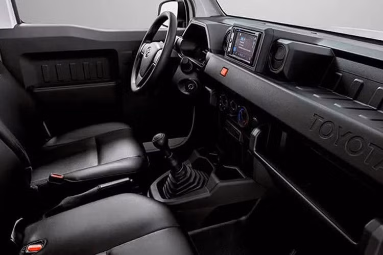Bên trong, cabin xe bám sát một công thức đơn giản: bọc ghế đen với điểm nhấn màu cam, không có màn hình thông tin giải trí và các tính năng thực dụng cơ bản. Chúng gồm gương và cửa sổ chỉnh điện, ghế chỉnh tay, điều hòa, 1 cặp loa, cổng USB Type-C và thậm chí cả một tấm che nắng.