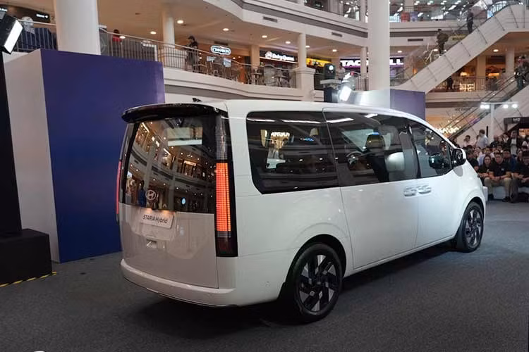 Về ngoại hình, mẫu xe MPV Hyundai Staria Hybrid 2026 về cơ bản vẫn mang phong cách tương lai quen thuộc trên phiên bản máy dầu, nổi bật với dải LED định vị kéo dài theo phương ngang và dáng thân bo tròn. Hyundai tạo điểm khác biệt bằng thiết kế mới ở khu vực lưới tản nhiệt.