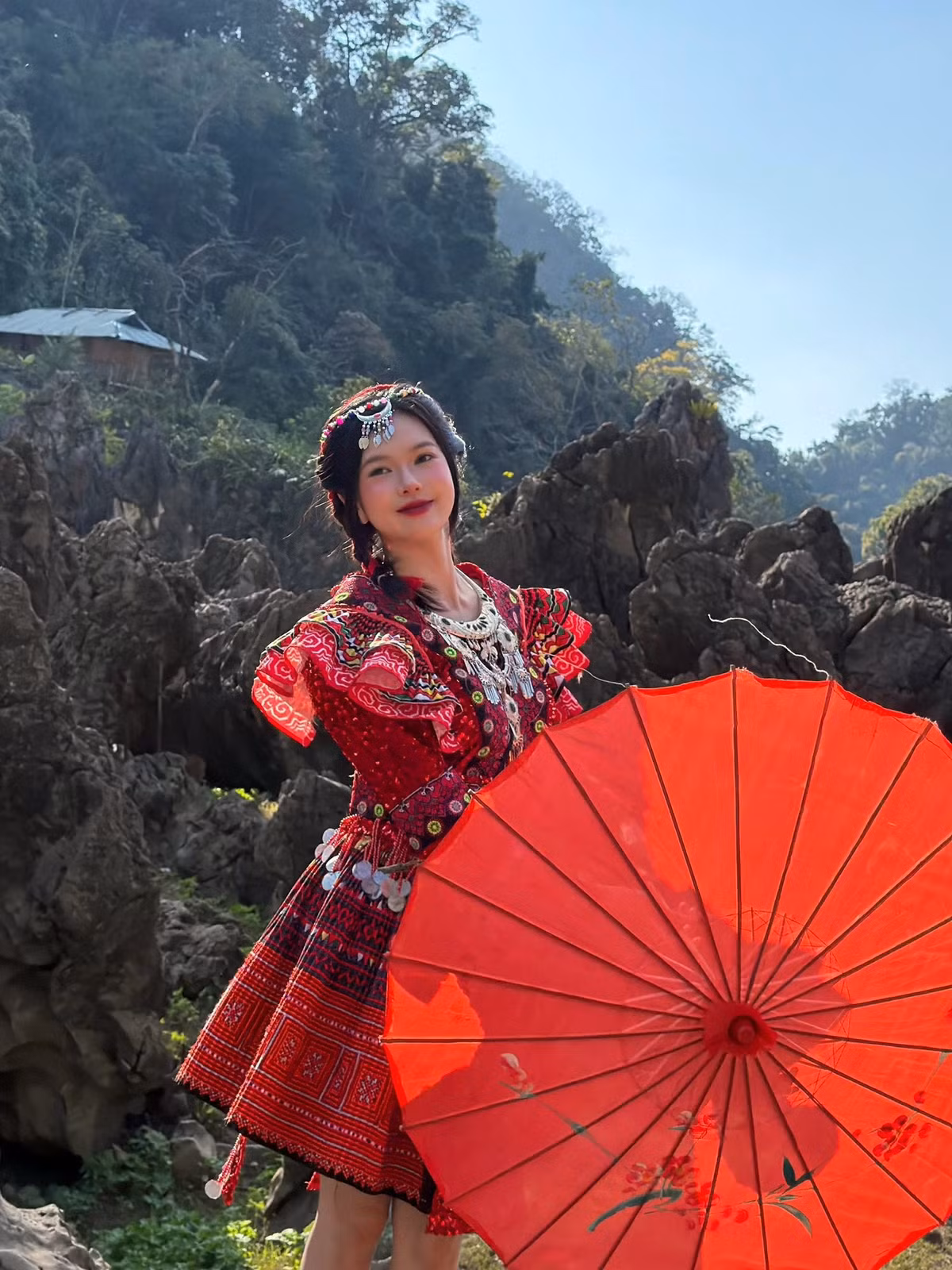 Những đường thêu tinh xảo, họa tiết hình học bắt mắt cùng chiếc ô giấy đỏ tạo điểm nhấn, giúp tổng thể hình ảnh vừa mang đậm bản sắc văn hóa, vừa toát lên nét trẻ trung, hiện đại.