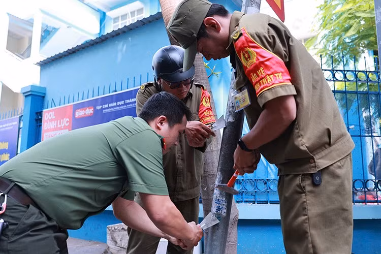 Lực lượng chức năng phường Tân Bình tham gia bóc dỡ quảng cáo.