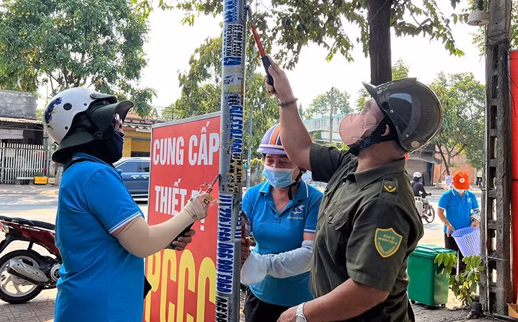 Các lực lượng và người dân tại các phường, xã trên địa bàn TP Hồ Chí Minh tham gia bóc dỡ quảng cáo sai quy định.