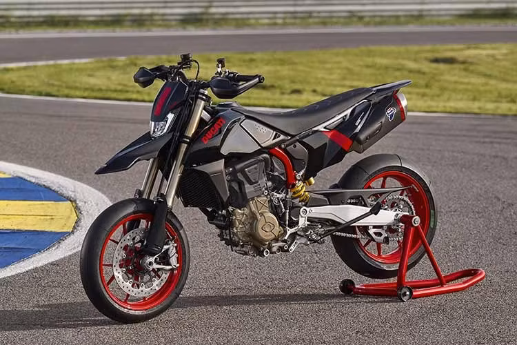 Ducati Hypermotard 698 Mono Nera 2026 với ngoại hình tạo ấn tượng bằng lớp sơn đen phủ gần như toàn bộ thân xe. Ducati lựa chọn cách phối màu tối giản nhưng đầy chủ đích, để các chi tiết như khung thép mắt cáo và bộ mâm đỏ nổi bật rõ nét hơn, tạo nên hiệu ứng tương phản đặc trưng của thương hiệu đến từ Borgo Panigale.
