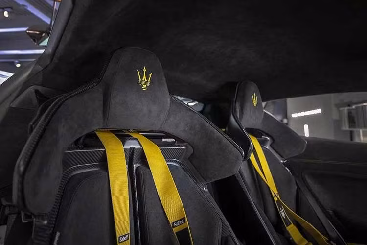 Khoang nội thất của Maserati GT2 Stradale Tribute to MC12 sử dụng ghế thể thao bọc Alcantara màu đen với logo cây đinh ba màu vàng trên tựa đầu, kết hợp dây đai an toàn xe đua bốn điểm thuộc gói Performance Plus.